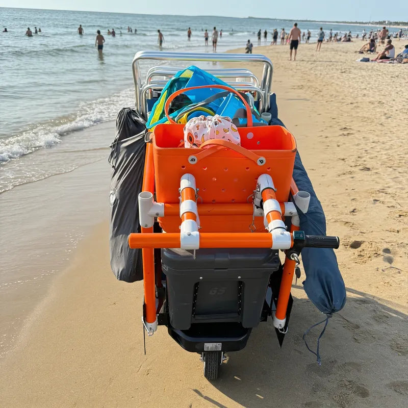 e-KRT electric beach cart with built-in chair mounts, cooler platform, and umbrella holders carrying beach gear