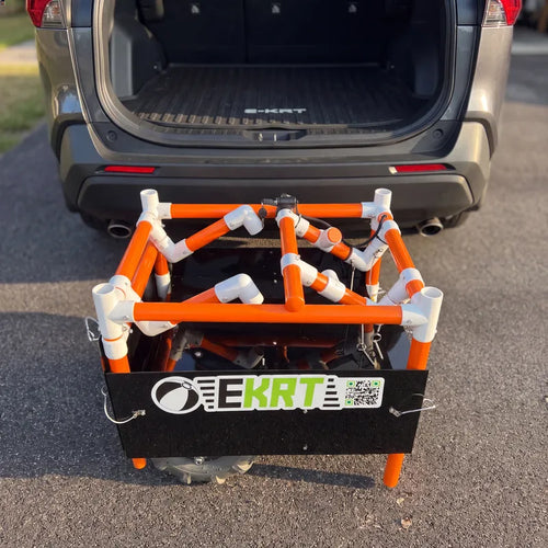 Folded e-KRT electric beach cart being loaded into the back of an SUV