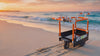 orange e-KRT standing on a beach and waves in Background